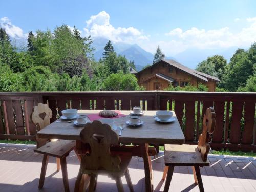 ヴィラール・シュル・オロンにあるApartment Le Mont Blanc 8 by Interhomeの木製テーブル、デッキ(椅子2脚付)