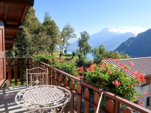 einen Tisch und Stühle auf einem Balkon mit Blumen in der Unterkunft Holiday Home Quang - GZO200 by Interhome in Garzeno