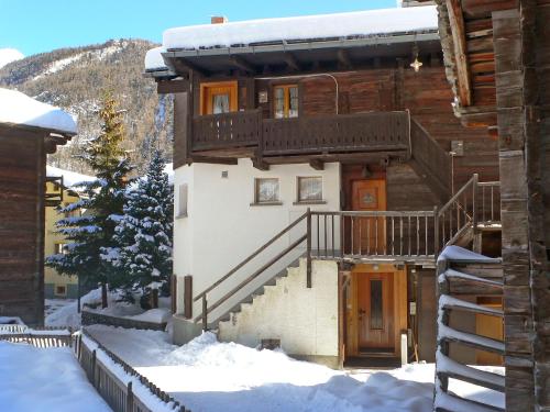 ein Haus mit einem Balkon und einer Treppe im Schnee in der Unterkunft Apartment Lauberhaus by Interhome in Zermatt