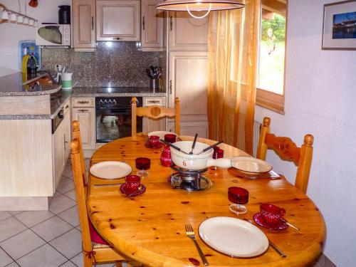 オヴロナにあるApartment Hauts de Morthey No 33 by Interhomeのキッチン(赤いバラの木製テーブル付)