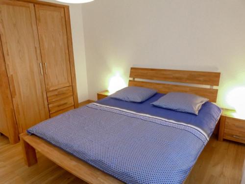 a bedroom with a bed with two blue pillows at Apartment Vermala-Soleil A-B-4 by Interhome in Vermala