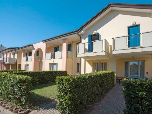 un edificio de apartamentos con arbustos delante de él en Holiday Home La Quercia-Le Farnie - CAO422 by Interhome, en La Fagiana