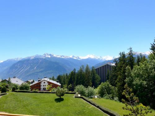 a green yard with mountains in the background at Apartment Terrasse Des Alpes 814 by Interhome in Vermala