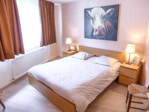 um quarto com uma cama com uma pintura de vaca na parede em Apartment Barzettes-Vacances B-9 by Interhome em Vermala