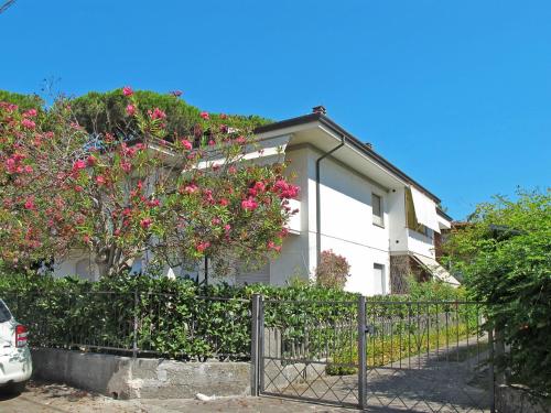 a white house with pink flowers and a fence at Apartment Dei Fiori by Interhome in Lido di Camaiore