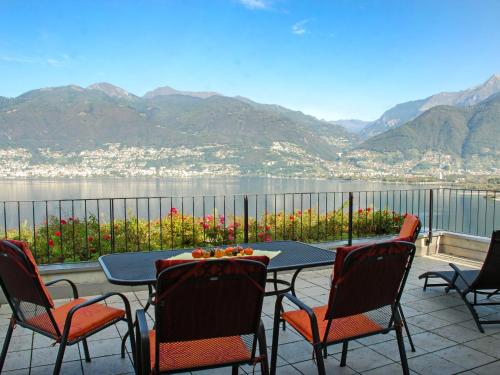 - une table et des chaises sur une terrasse avec vue sur l'eau dans l'établissement Apartment Coris by Interhome, à Vira