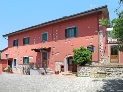 un edificio rojo con una calle adoquinada delante de él en Holiday Home Francesco by Interhome, en Nievole