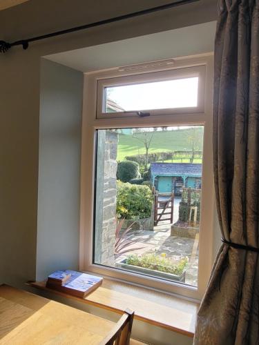 a window with a view of a garden at Mill Cottage in Llanddeiniol