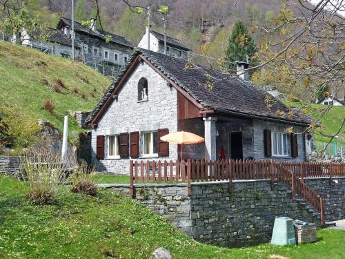 a small stone house with an umbrella in front of it at Holiday Home La Rustica by Interhome in Brione