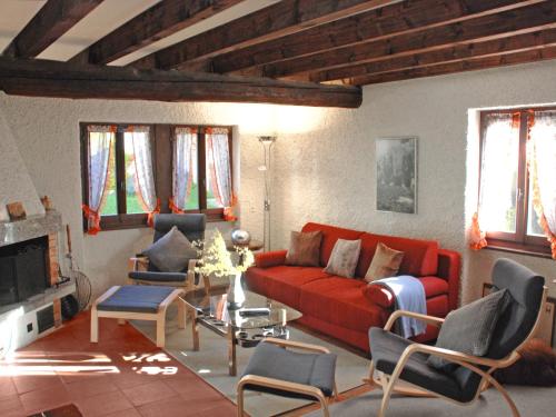 un soggiorno con divano rosso e sedie di Holiday Home Marianne by Interhome ad Aquila