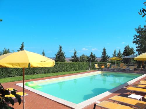 a swimming pool with chairs and an umbrella at Apartment Casa Nuova - Volterra - LAI130 by Interhome in Fattoria Spedaletto