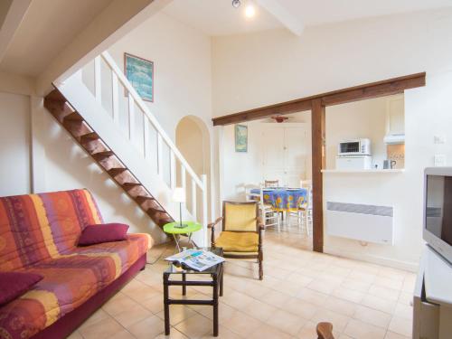 a living room with a couch and a staircase at Holiday Home Doumer by Interhome in Royan