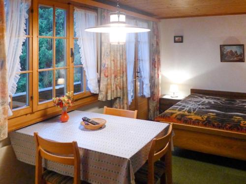 um quarto com uma mesa e uma cama e um quarto em Apartment Chalet Marie Rosa-3 by Interhome em Grindelwald