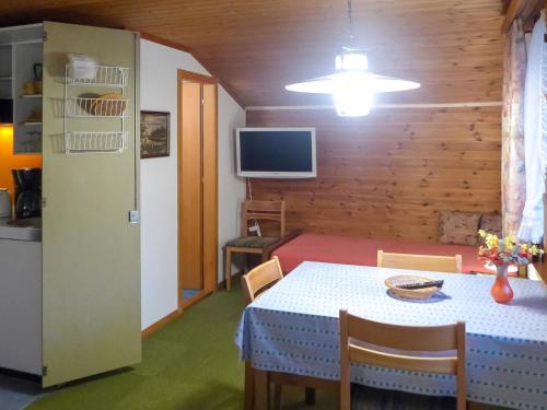 uma cozinha e sala de jantar com uma mesa e uma televisão em Apartment Chalet Marie Rosa-3 by Interhome em Grindelwald