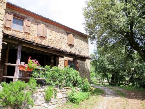 an old stone house with flowers in front of it at Apartment Paradiso Selvaggio-1 by Interhome in Paciano