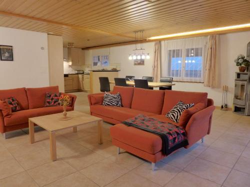 a living room with two red couches and a table at Apartment Oberei by Interhome in Wilderswil