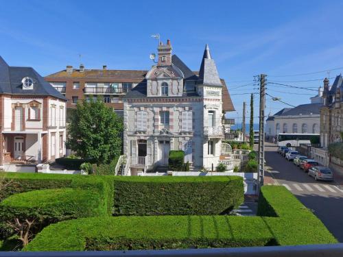 un grand bâtiment blanc avec une tour dans une rue dans l'établissement Apartment Le Manoir du Casino by Interhome, à Cabourg