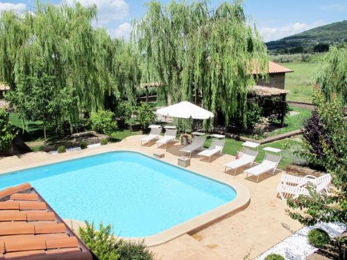 a swimming pool in a yard with chairs and an umbrella at Apartment Casa Domenico n- 1 by Interhome in Montefiascone