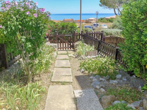 a garden with a wooden fence and flowers at Apartment Les Eaux Vives 1 & 2-7 by Interhome in Saint Pierre La Mer