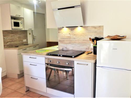 Il comprend une cuisine équipée d'une cuisinière et d'un réfrigérateur blanc. dans l'établissement Apartment Les Terrasses de la Méditerranée-1 by Interhome, à Saint Pierre La Mer