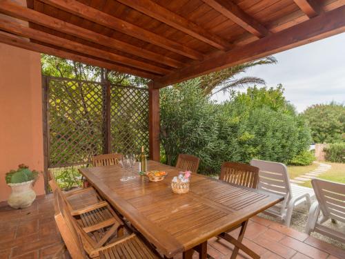モンテ・ナイにあるHoliday Home Villa Rossa - REI270 by Interhomeの木製テーブルと椅子付きのパティオ
