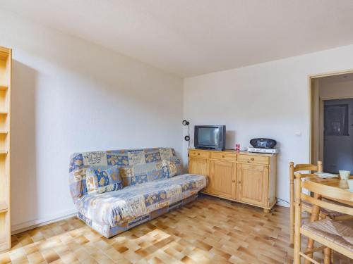 een woonkamer met een bank en een tv bij Apartment Le Centaure by Interhome in Cap d'Agde