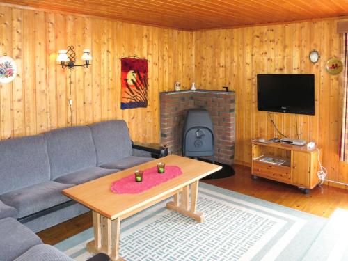 a living room with a couch and a fireplace at Holiday Home Neset - SOW043 by Interhome in Lyngdal