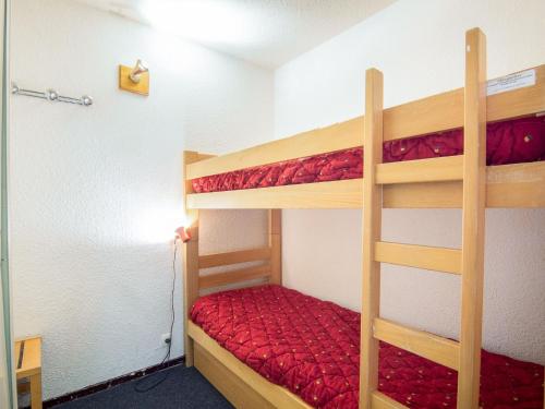 - une chambre avec 2 lits superposés et des draps rouges dans l'établissement Apartment Lunik Orion-29 by Interhome, au Corbier