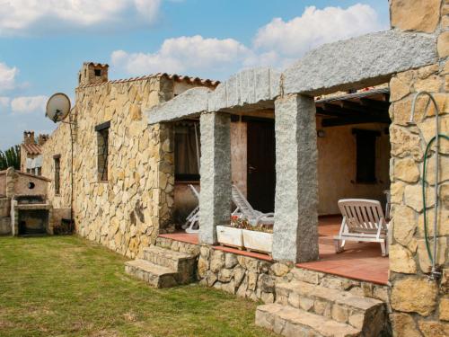 una vista esterna di una casa in pietra con patio di Holiday Home Ville Sant'Elmo - REI241 by Interhome a Monte Nai