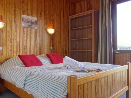 une chambre avec un grand lit avec des oreillers rouges dans l'établissement Apartment Le 2100 A et B - Lavachet-9 by Interhome, à Tignes
