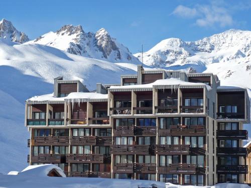 un bâtiment dans la neige avec des montagnes en arrière-plan dans l'établissement Apartment Le Grand Tichot A et B - Val Claret-3 by Interhome, à Tignes