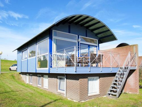 een huis met een rond dak en een balkon bij Holiday Home Lauwersmeer - LWM101 by Interhome in Oostmahorn