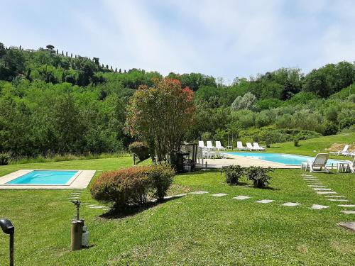 um quintal com uma piscina com cadeiras e árvores em 2 bedrooms apartement with shared pool garden and wifi at Montecarlo em Montecarlo