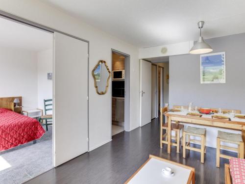 a bedroom and a living room with a dining room table at Apartment Pegase Phenix-15 by Interhome in Le Corbier