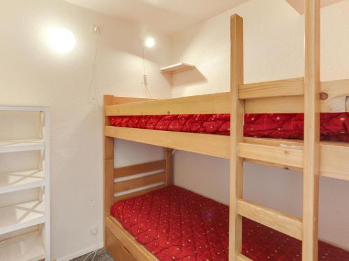 Cette chambre comprend 2 lits superposés dotés de draps rouges. dans l'établissement Apartment Pegase Phenix-15 by Interhome, au Corbier