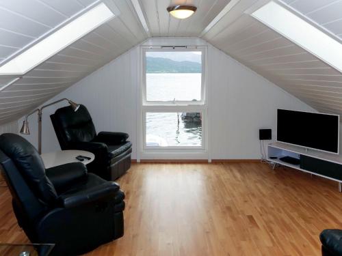 a living room with two chairs and a flat screen tv at Holiday Home Rorbu - FJS555 by Interhome in Naustdal i Sunnfjord