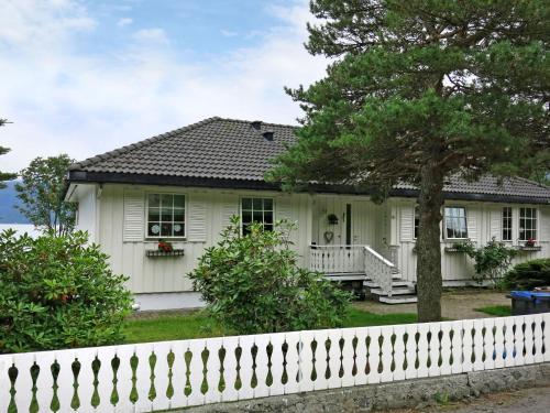 a white house with a white picket fence at Holiday Home Villa Syltebær by Interhome in Kyrkjebø