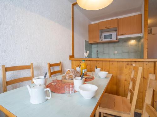 - une cuisine avec une table et des plats blancs dans l'établissement Apartment Grandes Platières II-12 by Interhome, à Tignes