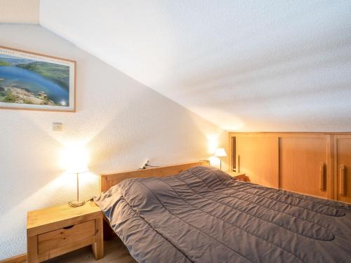 レ・メニュアールにあるApartment Les Asters-1 by Interhomeのベッドルーム1室(ベッド1台、テーブルの上にランプ2つ付)