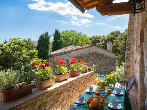 カステル・サン・ジミニャーノにあるHoliday Home Sissi by Interhomeの花の咲くバルコニーに果物や野菜を用意したテーブル