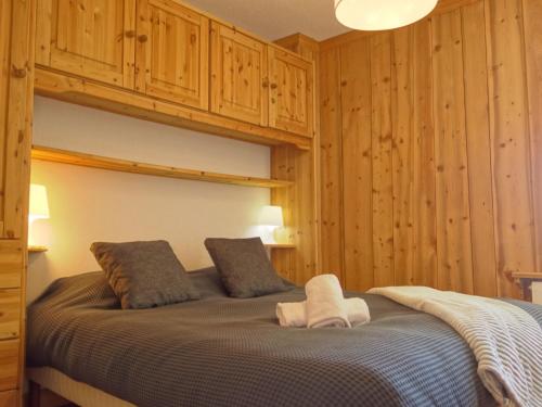 - une chambre avec un grand lit et des murs en bois dans l'établissement Apartment Le Curling A - Val Claret-13 by Interhome, à Tignes