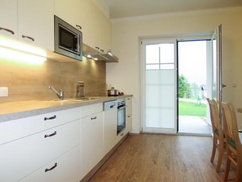 eine Küche mit einer Spüle und einer Mikrowelle in der Unterkunft Holiday Home Siedlerhof - HAE180 by Interhome in Haus im Ennstal