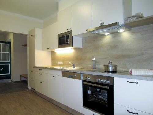 een keuken met witte kasten en een fornuis met oven bij Holiday Home Siedlerhof - HAE180 by Interhome in Haus im Ennstal