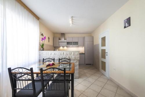 a kitchen and dining room with a table and chairs at Holiday Home Swiss in Cavtat