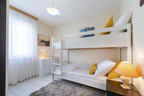 a bedroom with two bunk beds and a lamp at Holiday Home Swiss in Cavtat