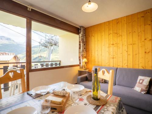 a living room with a table and a couch at Apartment L'Argousier-1 by Interhome in Les Menuires