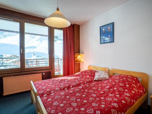 una camera con un letto con copriletto rosso di Apartment Le Curling B-20 by Interhome a Tignes