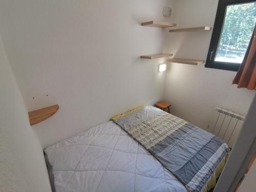 a small bedroom with a bed and a window at Boost Your Immo Gardette Réallon A11 in Réallon