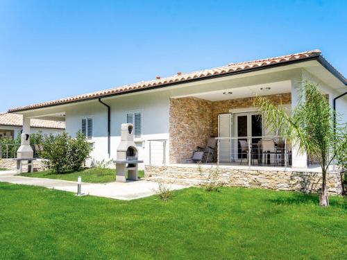a house with a patio and a yard at Holiday Home A Suara-2 by Interhome in Ghisonaccia