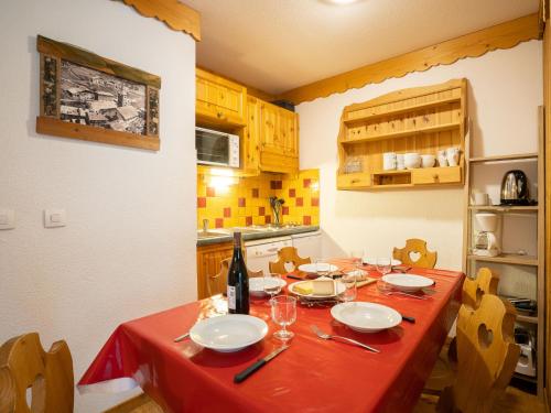a kitchen with a table with a red table cloth at Apartment Balcons D'Olympie-5 by Interhome in Les Menuires